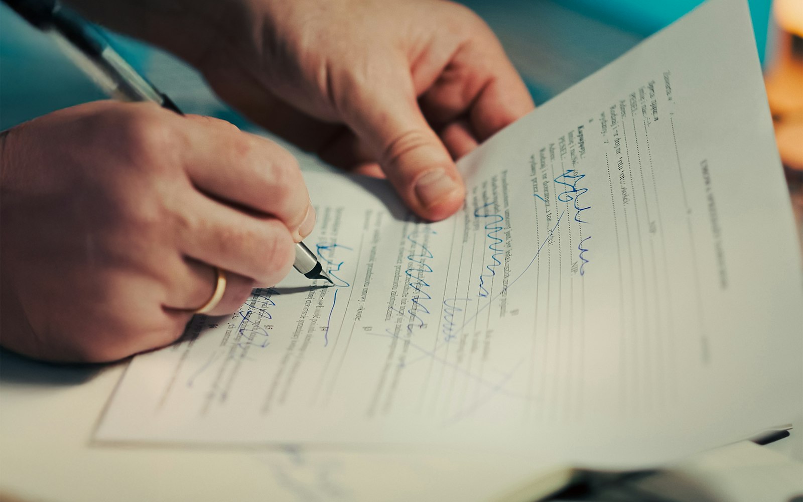 Man signing a document with a pen, the moment to pause before agreeing to car accident lawsuit funding