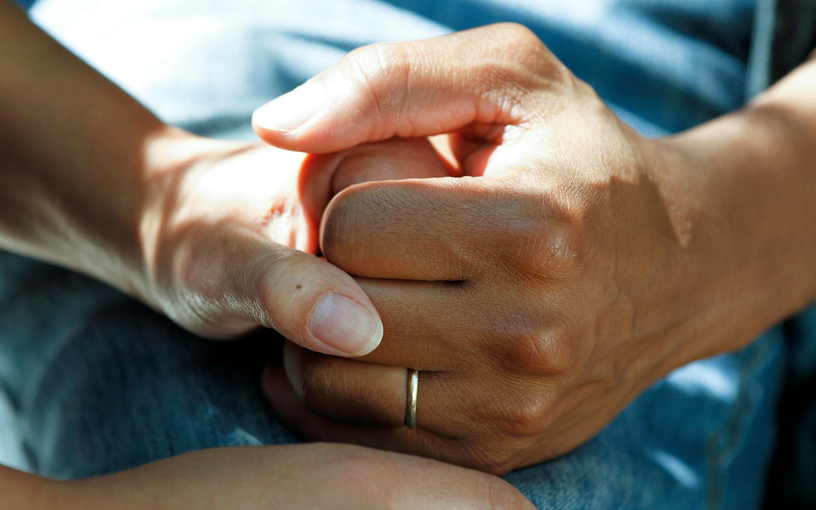 Two people holding hands in comfort, representing the families a Long Island wrongful death attorney helps