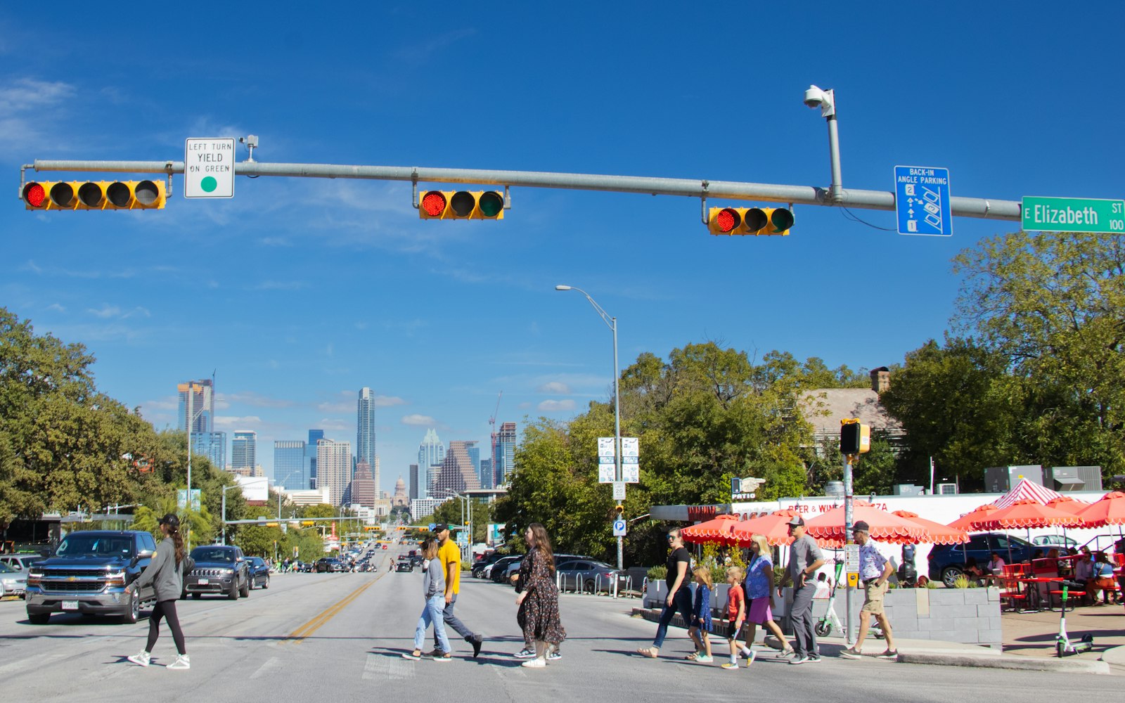 Pedestrians crossing a busy intersection with traffic signals, the kind of crossing a Westbury personal injury lawyer sees crashes at