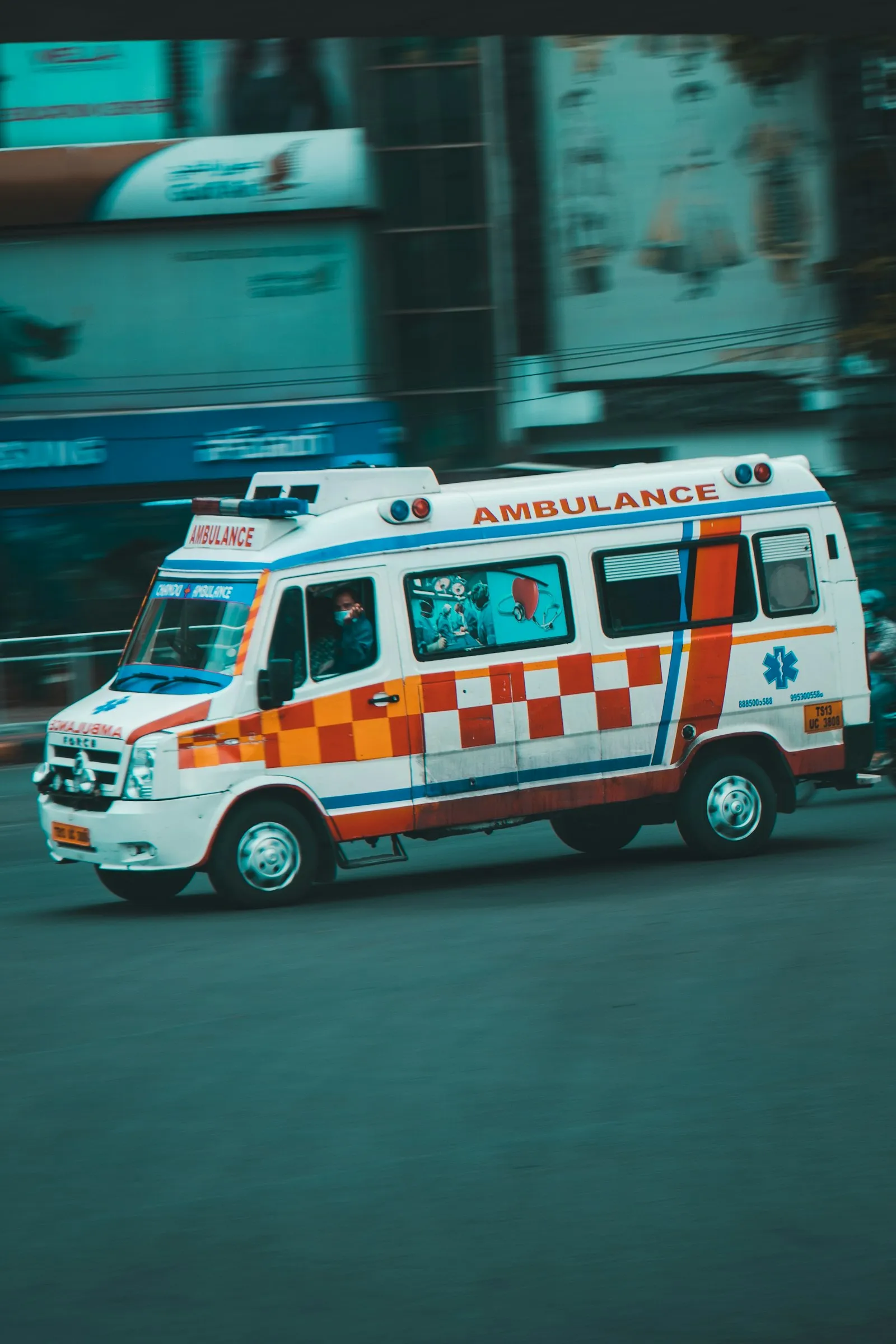 Abogado de accidentes automovilísticos Elmhurst: ambulancia conduciendo por una calle de la ciudad