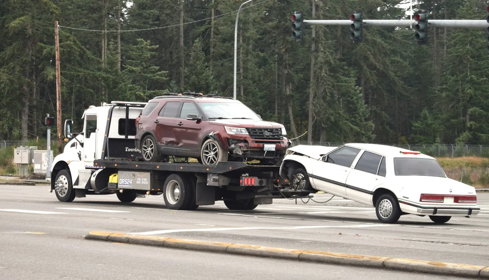 Car accident lawyer Freeport NY: tow truck towing a damaged car on the road
