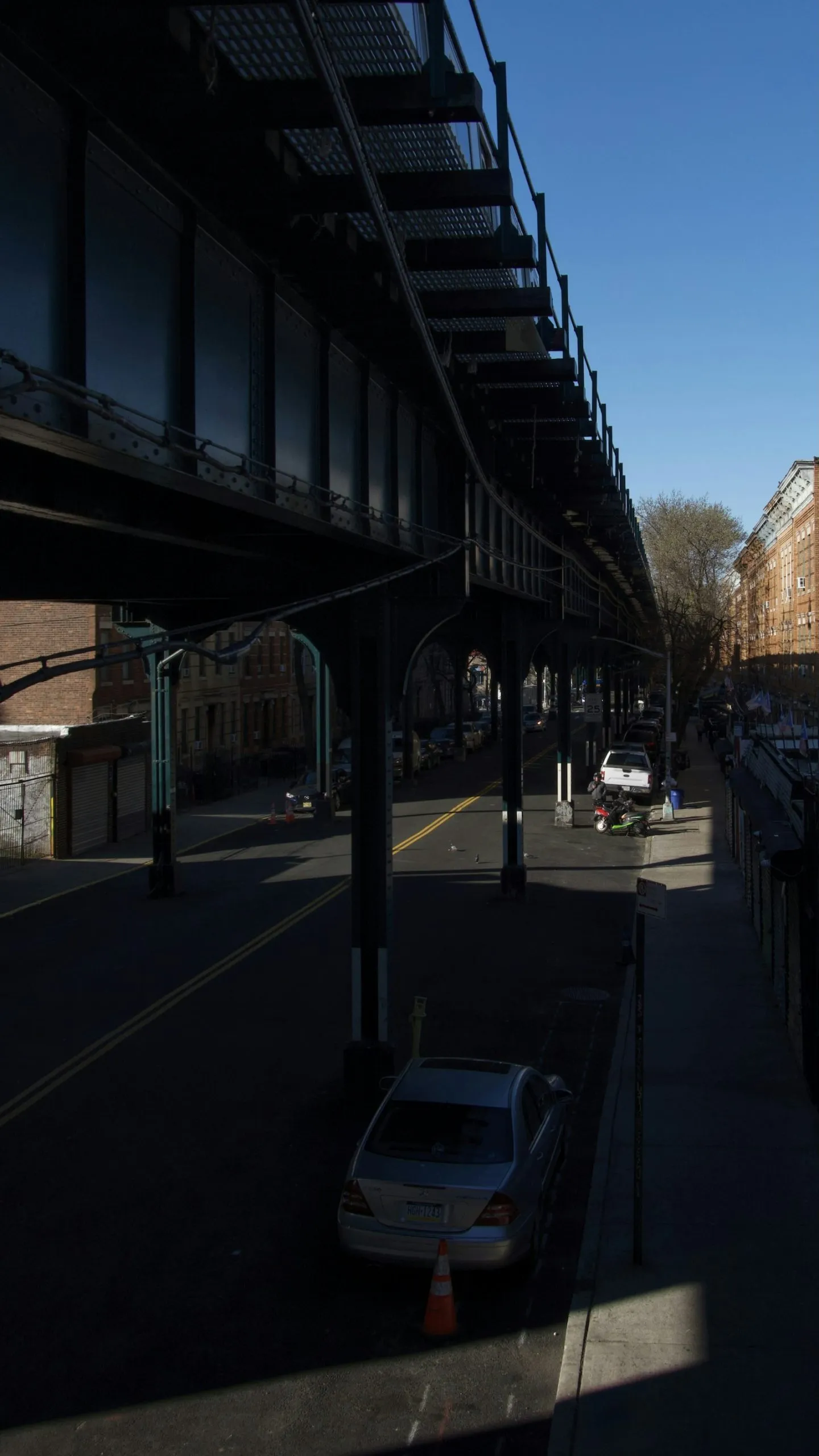 Car accident lawyer in Jamaica Queens NY: cars on a street beneath elevated train tracks