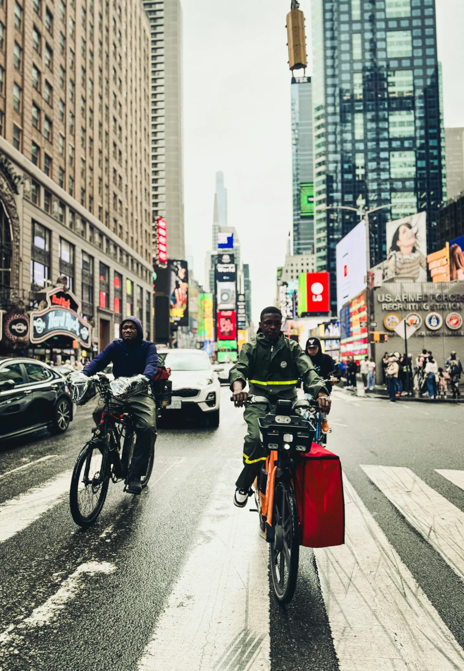 E-bike accident attorney Arverne: two delivery riders in a bike lane along a busy city street