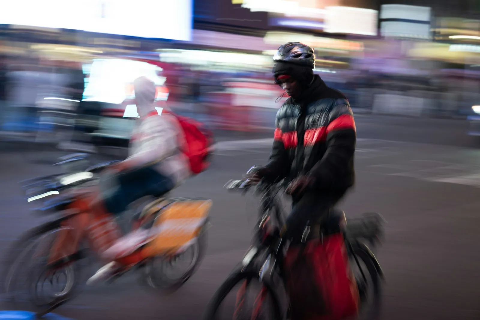 E-bike accident attorney Beechhurst image: delivery riders moving through a city street at night in motion blur