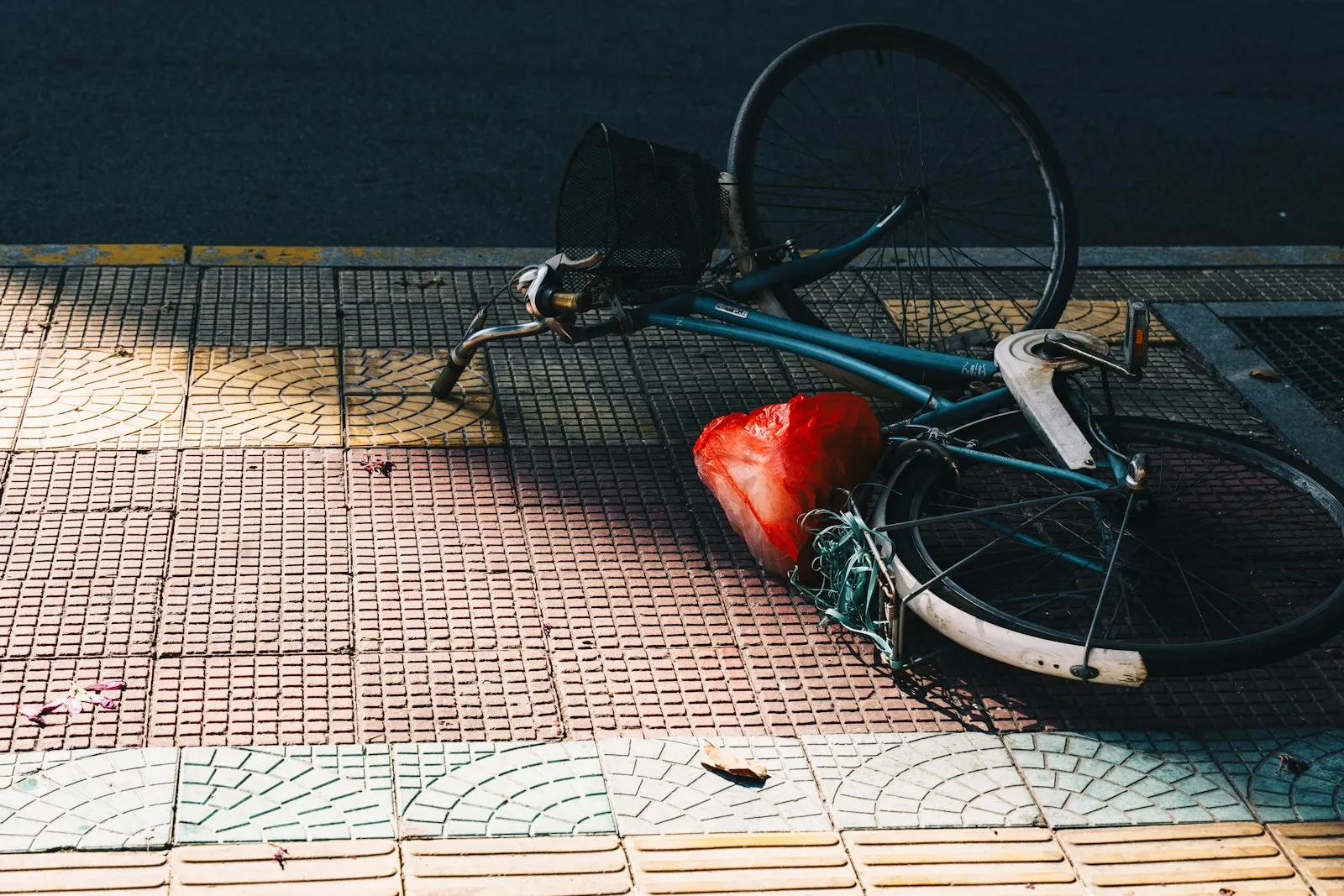 Bicycle knocked over on its side on a sidewalk, the kind of aftermath an Auburndale e-bike accident lawyer asks clients to photograph