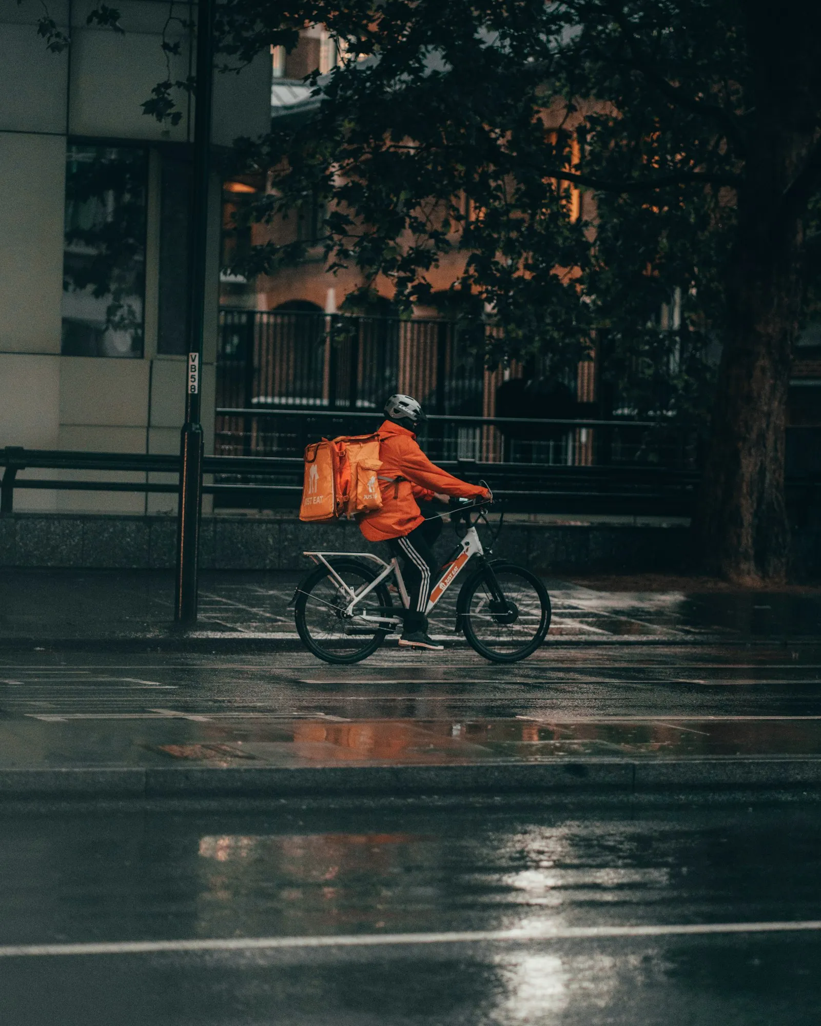 E-bike accident attorney Broad Channel image: delivery rider carrying an orange bag on a wet street at night