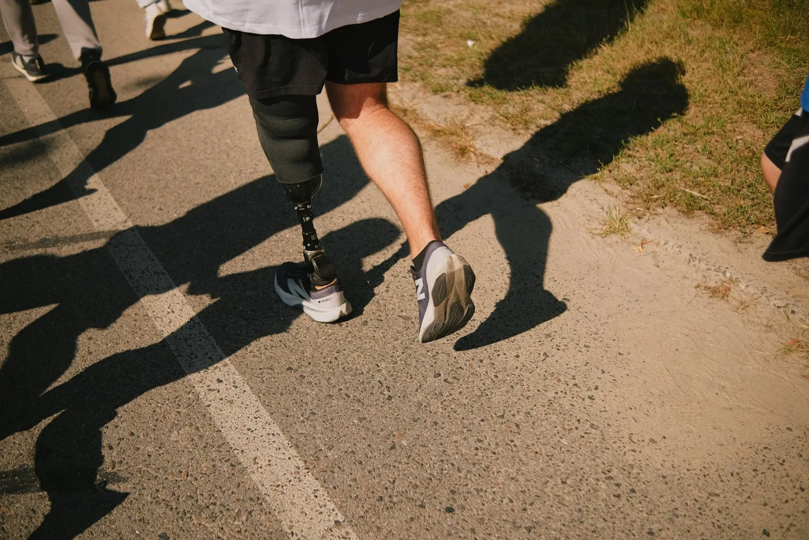 Coureur avec une jambe prothétique sur un chemin en asphalte, un rappel de la planification à long terme qu'un avocat spécialisé dans les blessures d'amputation considère