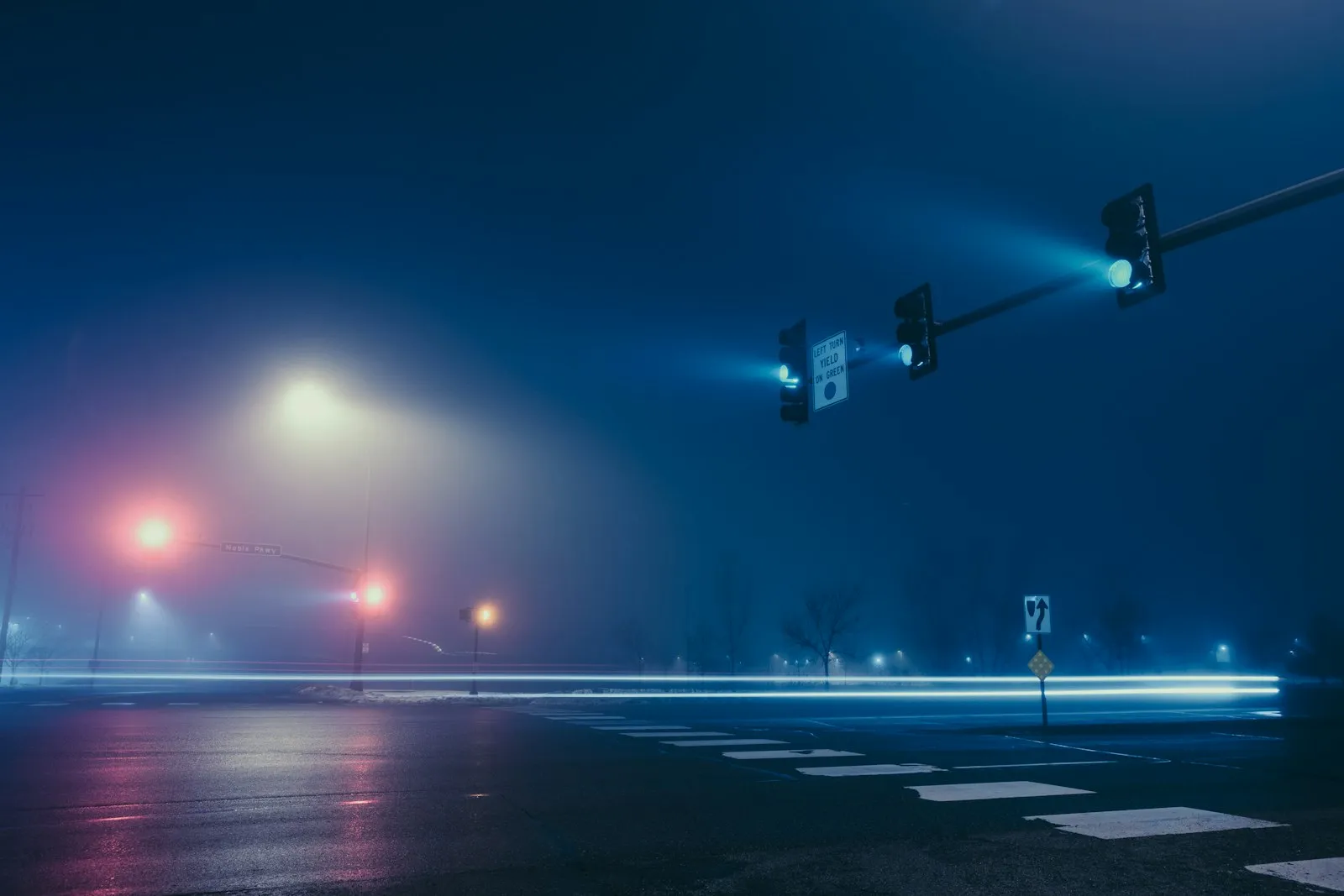 Traffic signals over an empty intersection on a foggy night, for a Lynbrook car accident attorney article