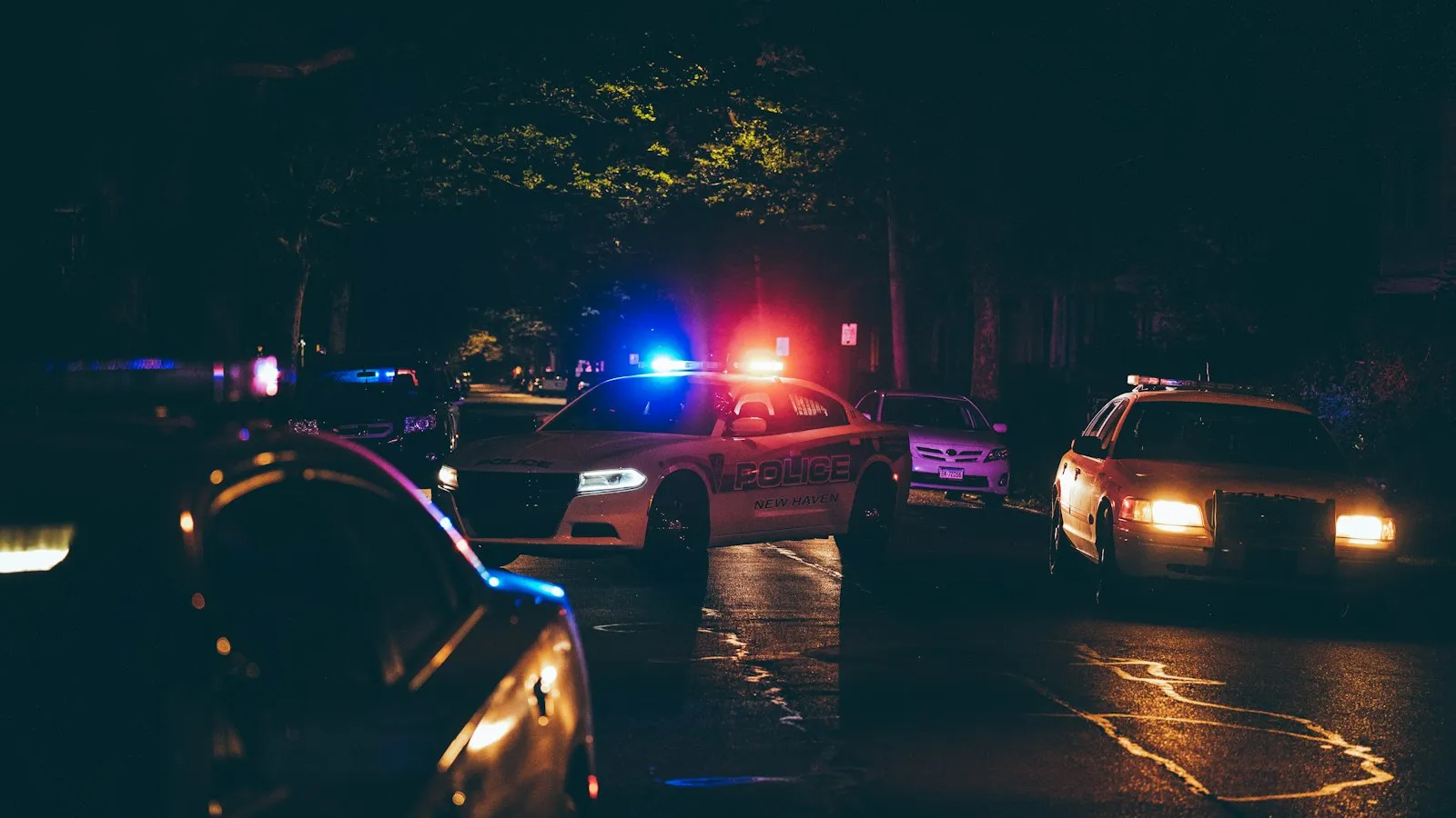 Police cars with flashing lights at a nighttime crash scene, for a Lynbrook car accident attorney guide