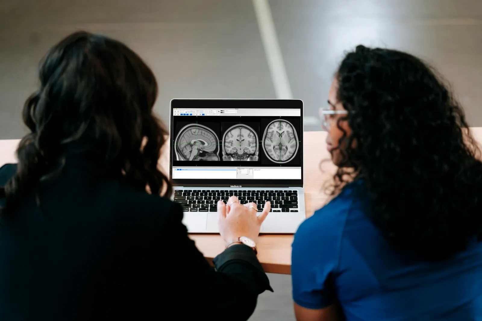 Doctor and patient reviewing brain scan images on a laptop during a concussion follow-up relevant to an injury lawyer