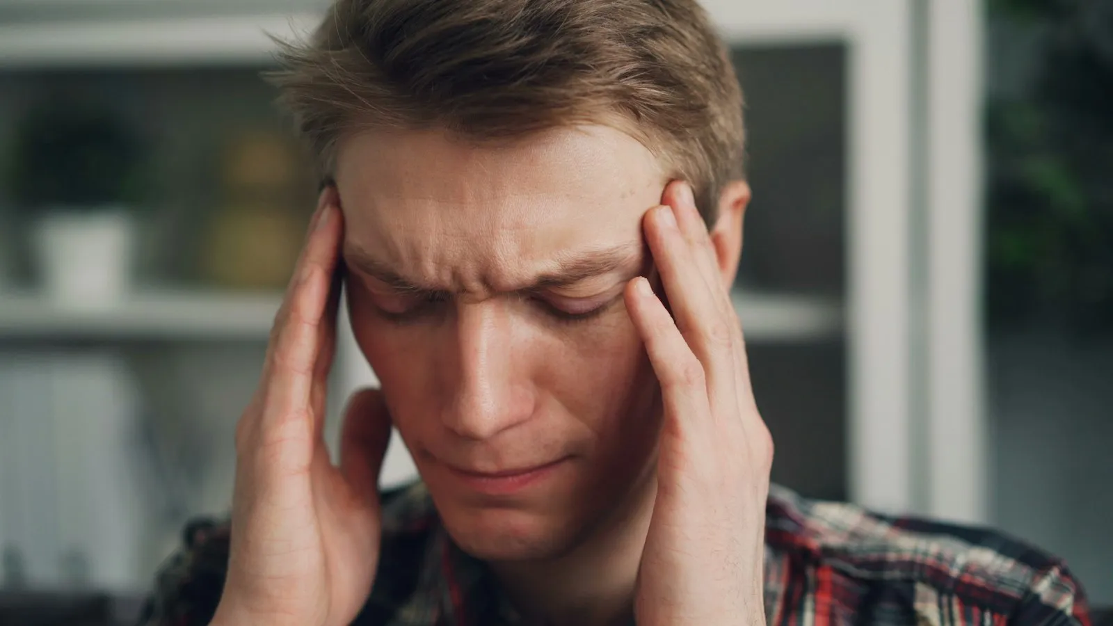 Man holding his head in both hands in pain after a crash, the kind of concussion symptoms a car accident lawyer documents