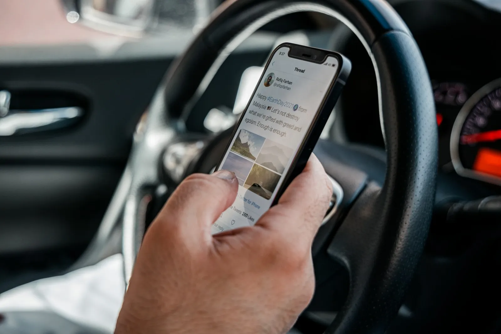 Distracted Driving Accident Lawyer in Bellerose – driver holding a smartphone behind the wheel