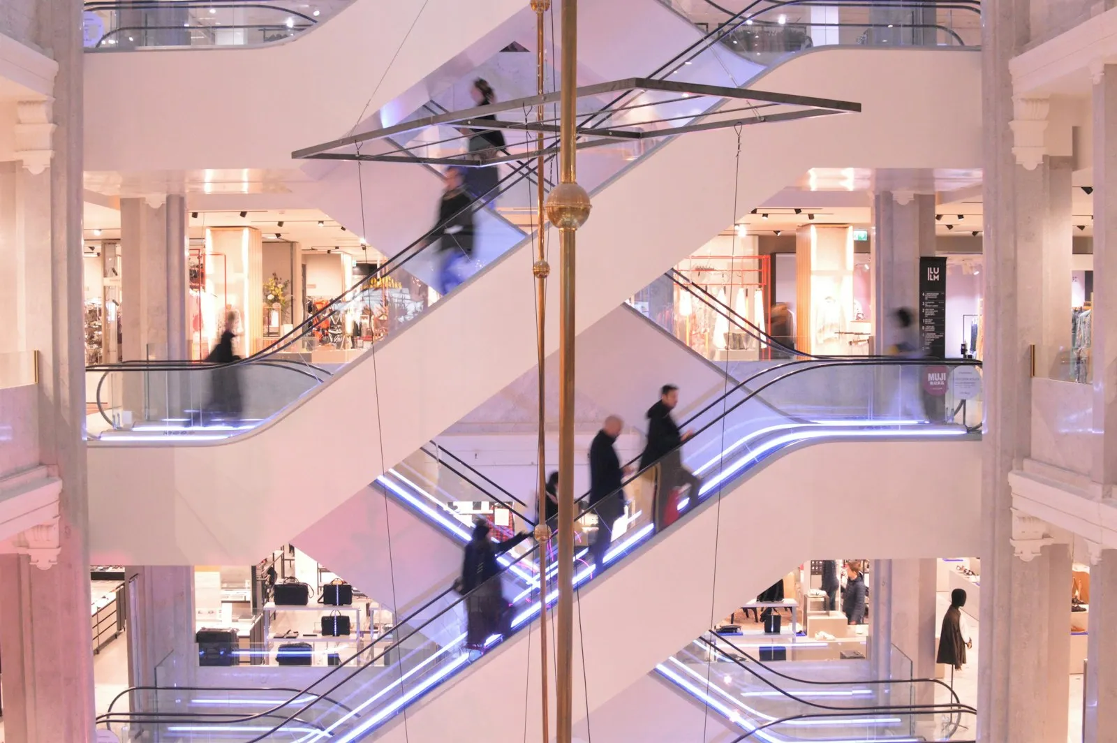 Shoppers riding crisscrossing escalators in a multi-level mall, the setting for many escalator injury cases an attorney reviews