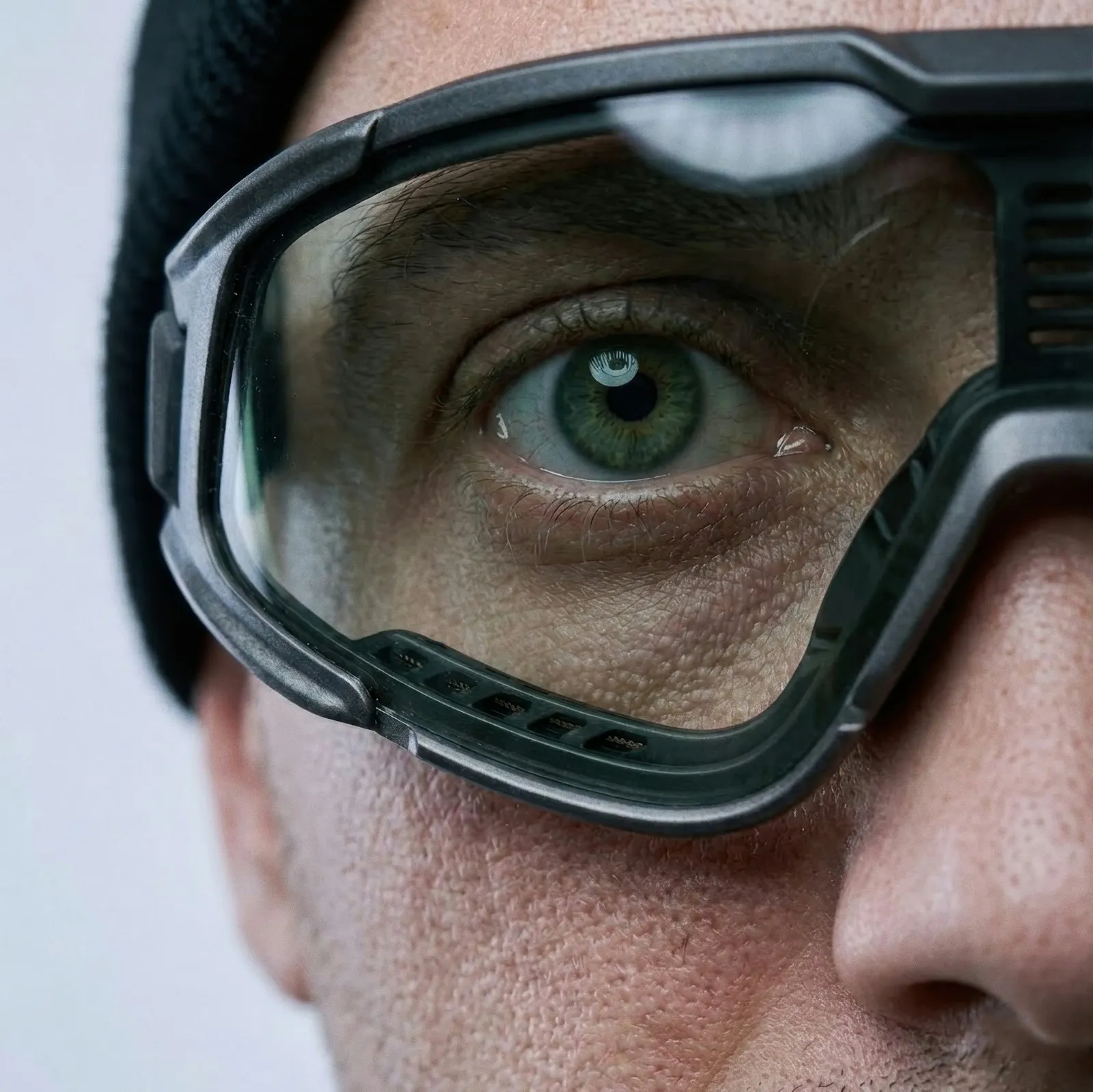 Close-up of a worker's eye behind clear safety goggles, eye injury attorney job-site claims
