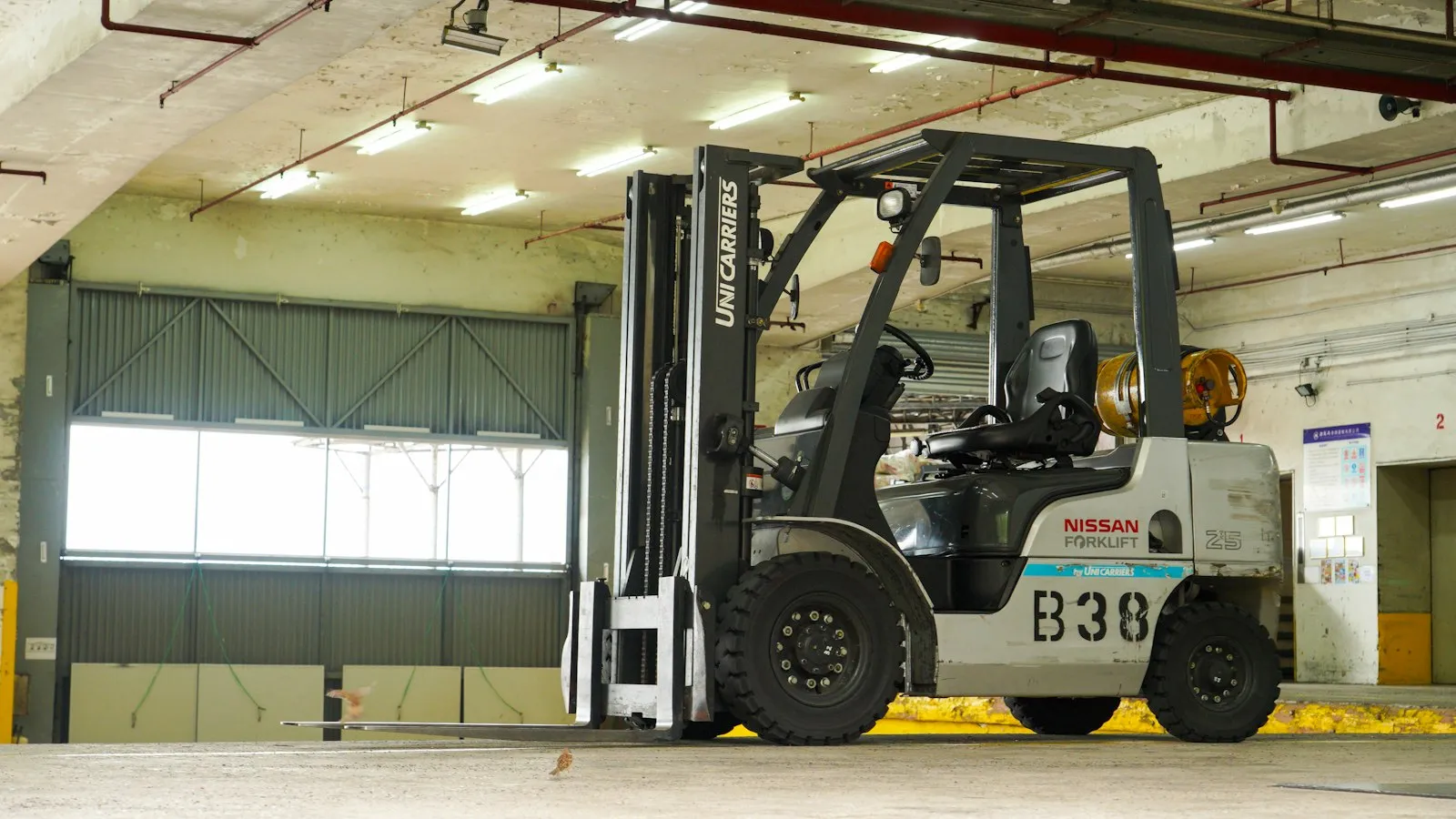 Forklift parked in a bright loading area near the dock, relevant to a forklift injury attorney's case review