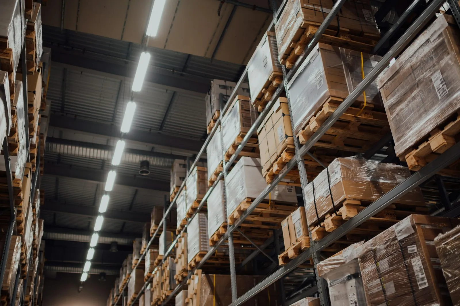 Tall warehouse shelving racks stacked with boxes, a falling-load hazard a forklift accident attorney examines