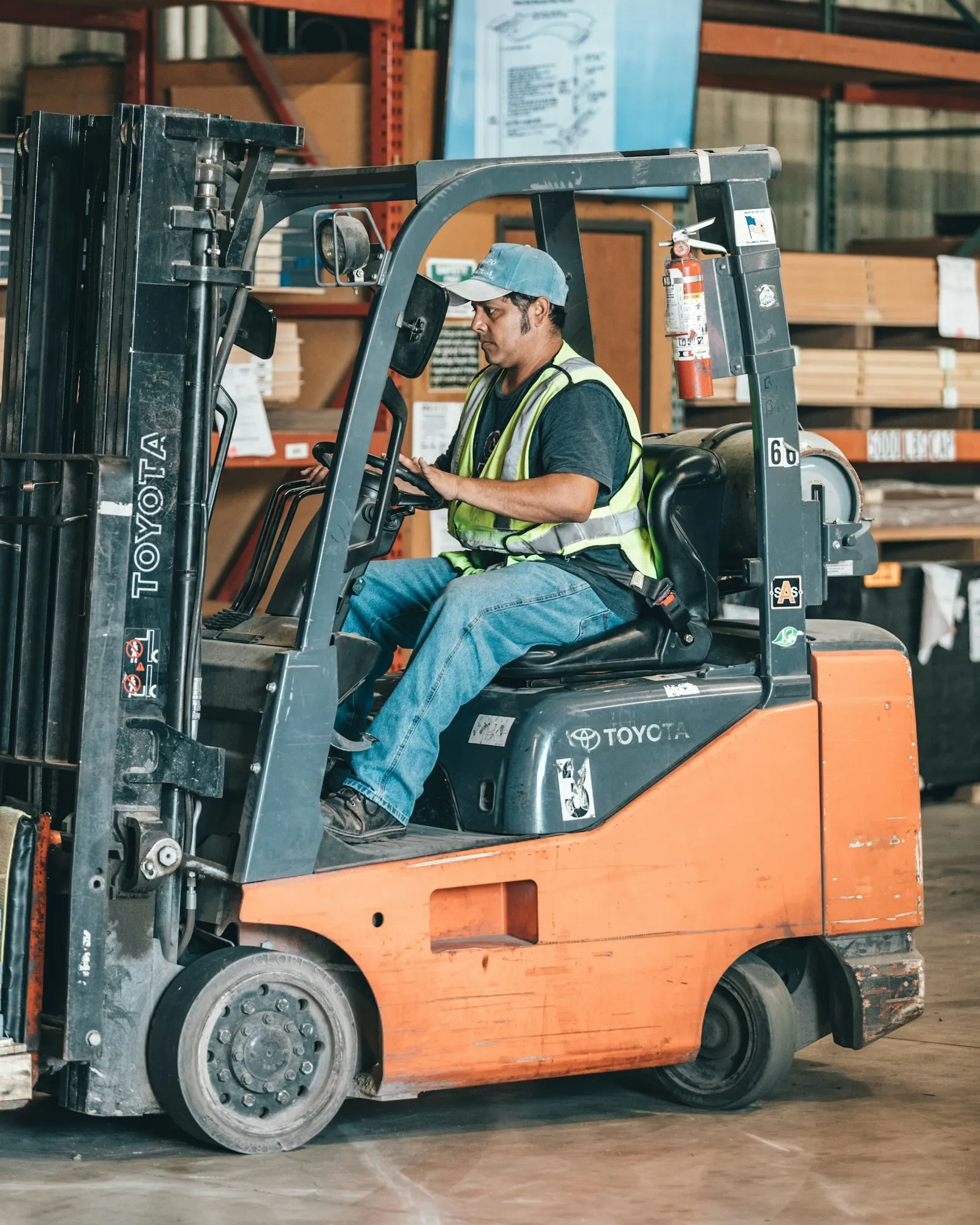 Forklift operator driving a loaded forklift inside a warehouse, the type of scene a forklift accident lawyer reviews