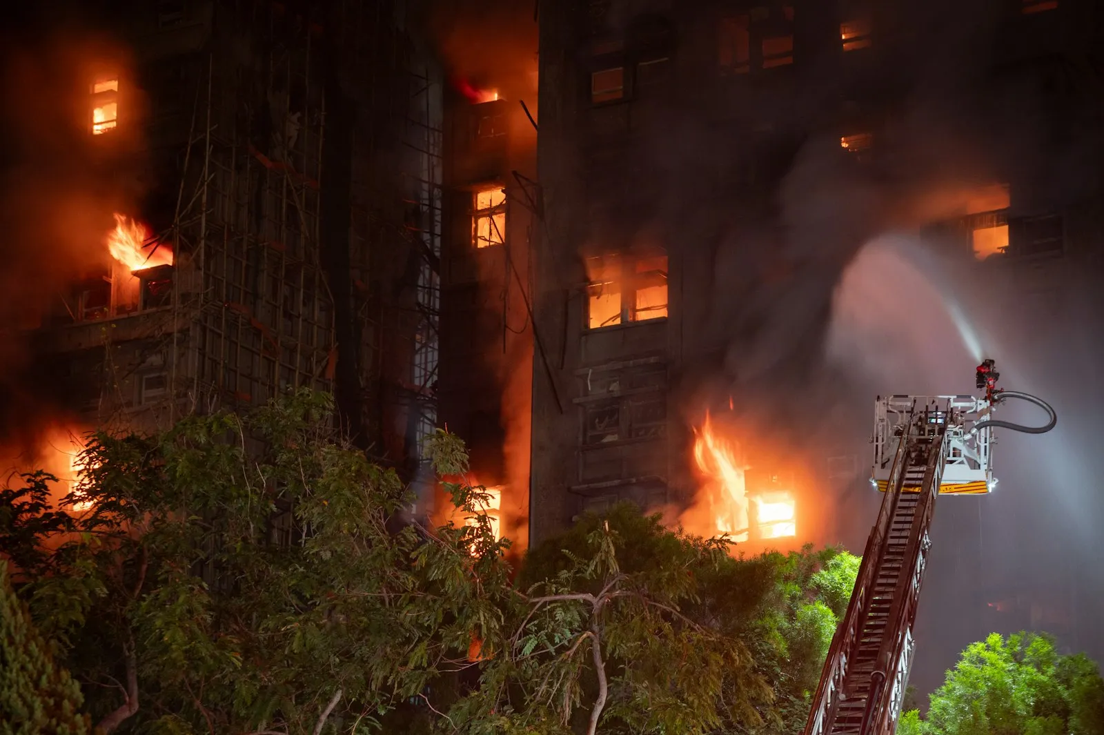 Firefighters spraying water on a burning building at night, the kind of scene a gas explosion attorney works to document