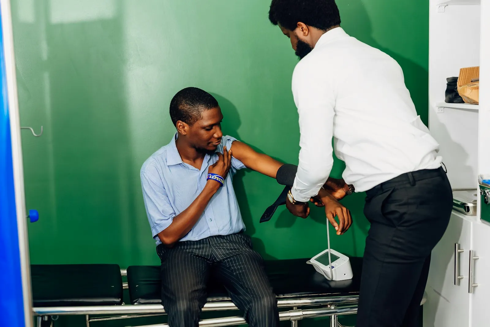 Independent medical examination: doctor checking the arm of a seated man in an exam room
