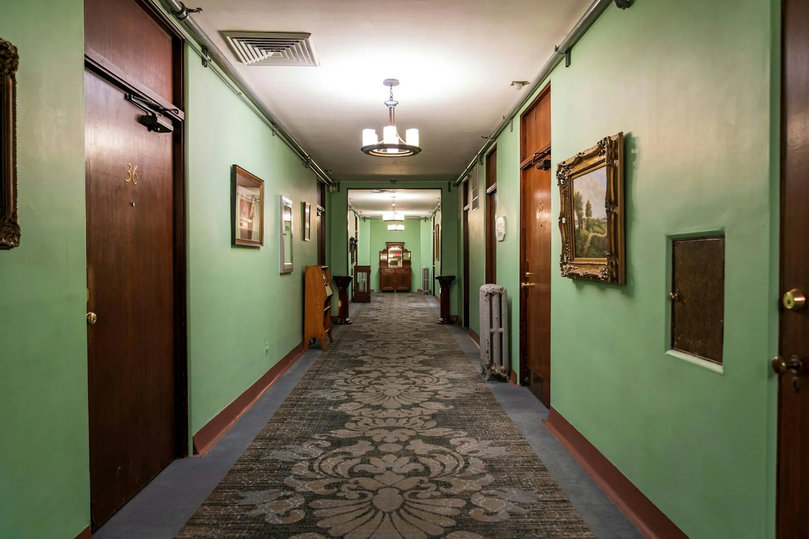 Long apartment hallway with patterned carpet and green walls, reviewed by a landlord negligence attorney