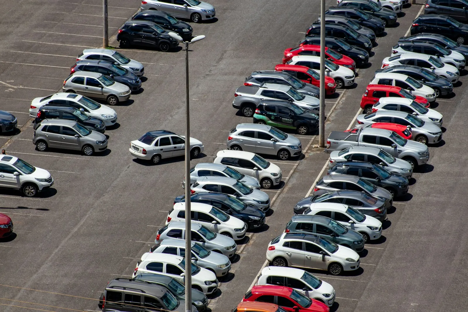 Rows of parked cars in a crowded parking lot seen from above, the scene a parking lot accident lawyer often reviews
