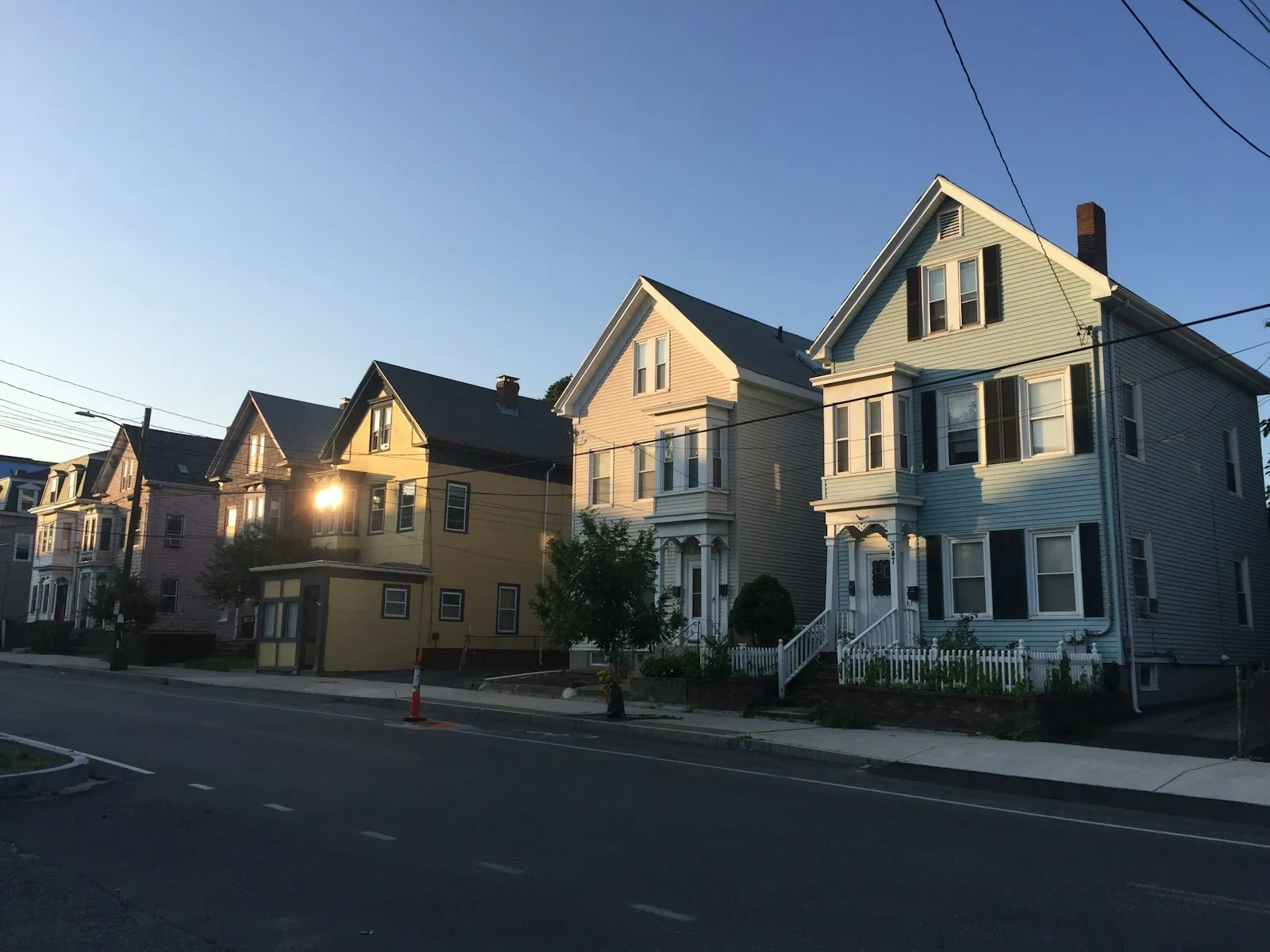 Fila de casas de dos pisos a lo largo de una calle residencial al atardecer, que ilustra una guía de abogado de lesiones personales de Cambria Heights