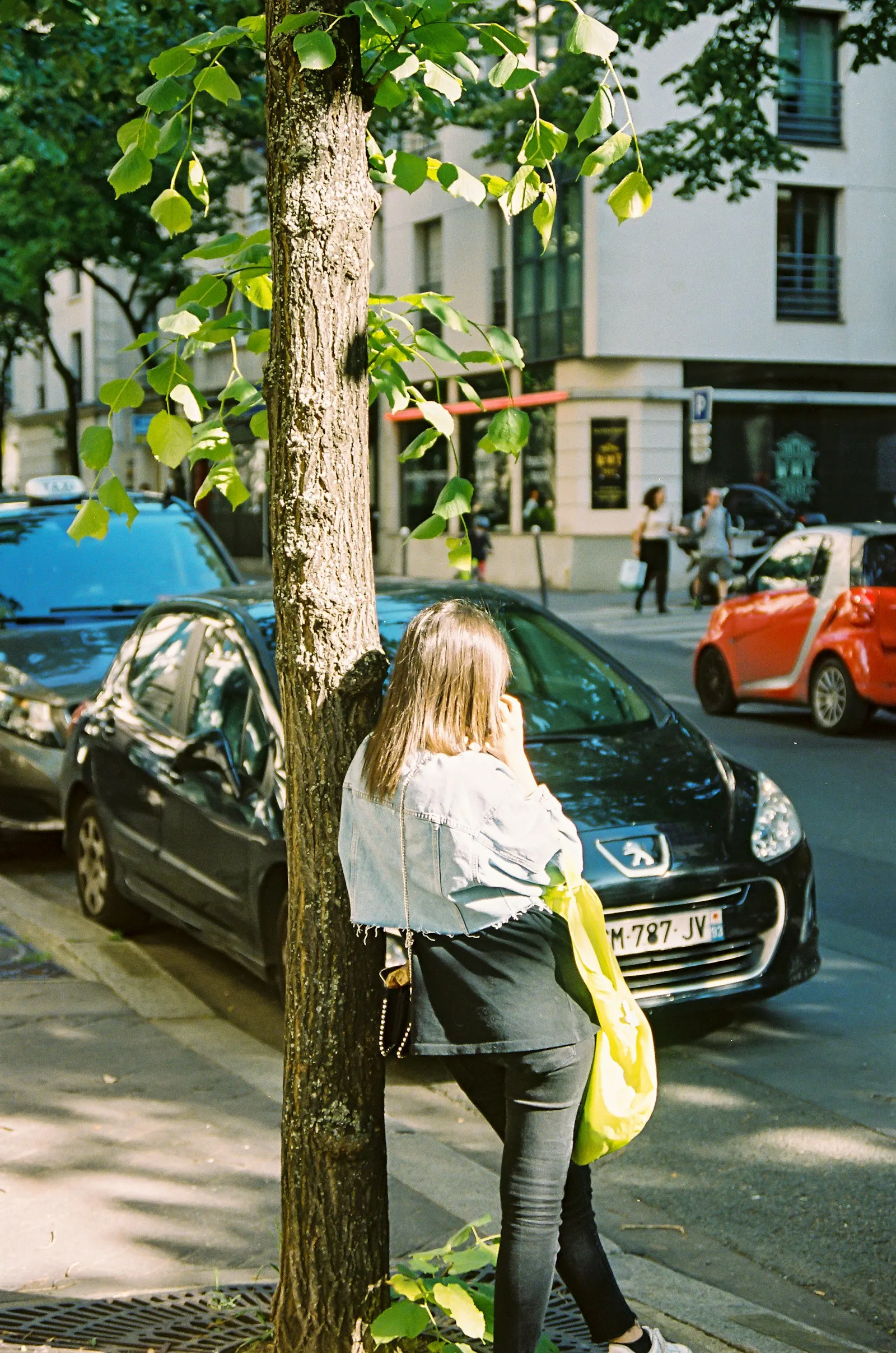 Woman standing beside a car at the curb