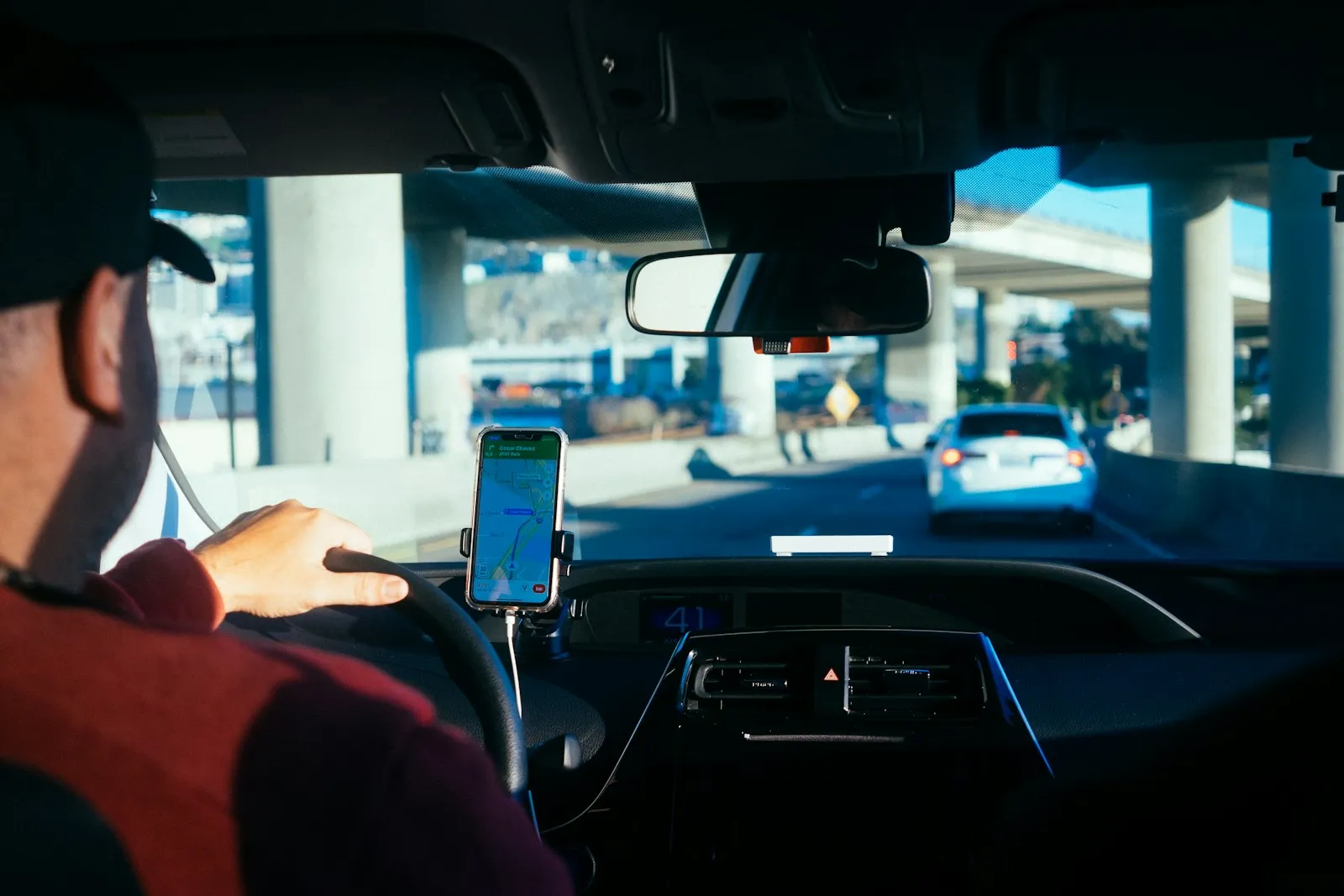 Driver following a smartphone navigation app mounted on the dashboard