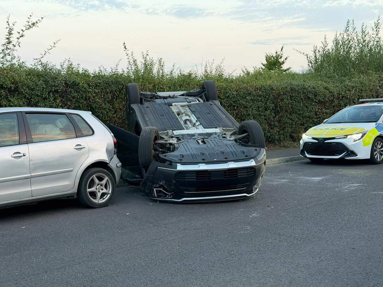 Overturned car beside a police vehicle after a crash