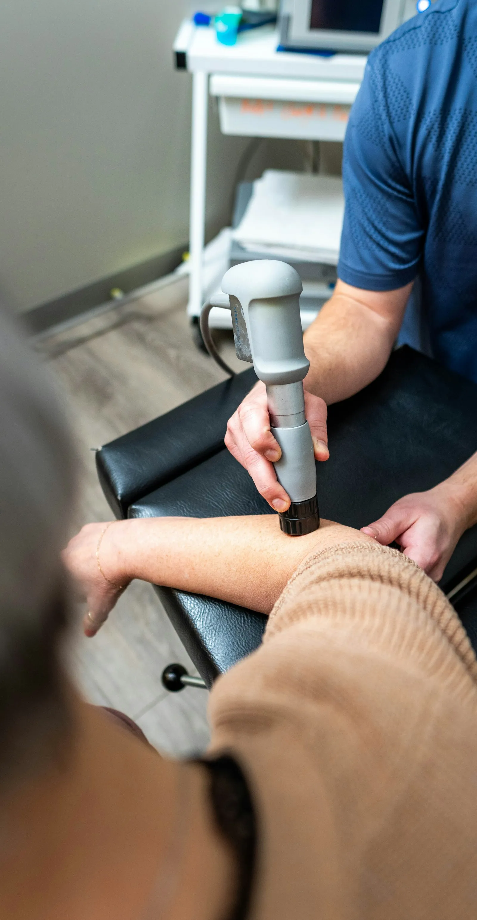 Therapist treating a patient's arm during physical therapy