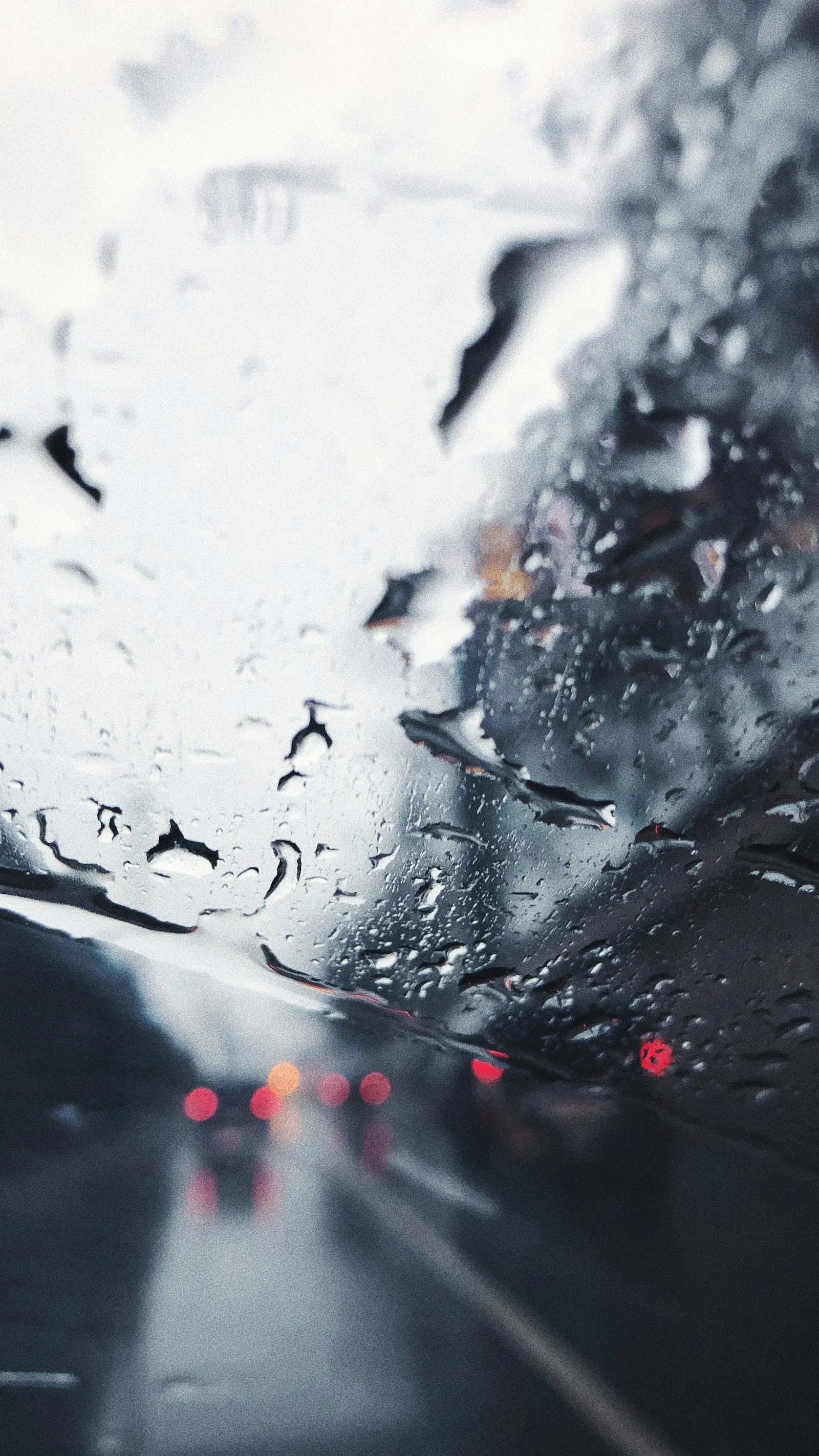 Rain-covered windshield seen from inside a car