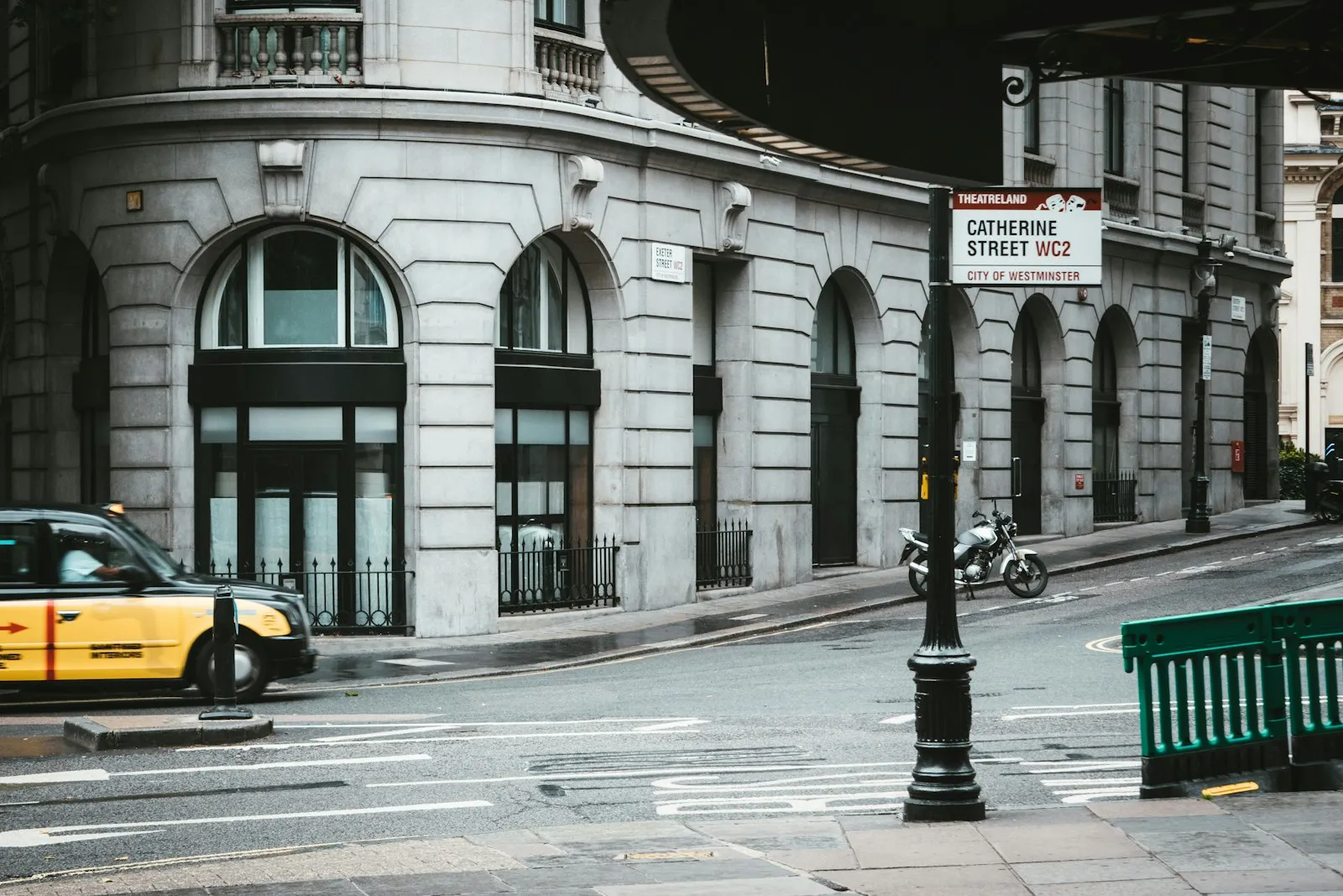 Yellow taxi cab on the road near city buildings