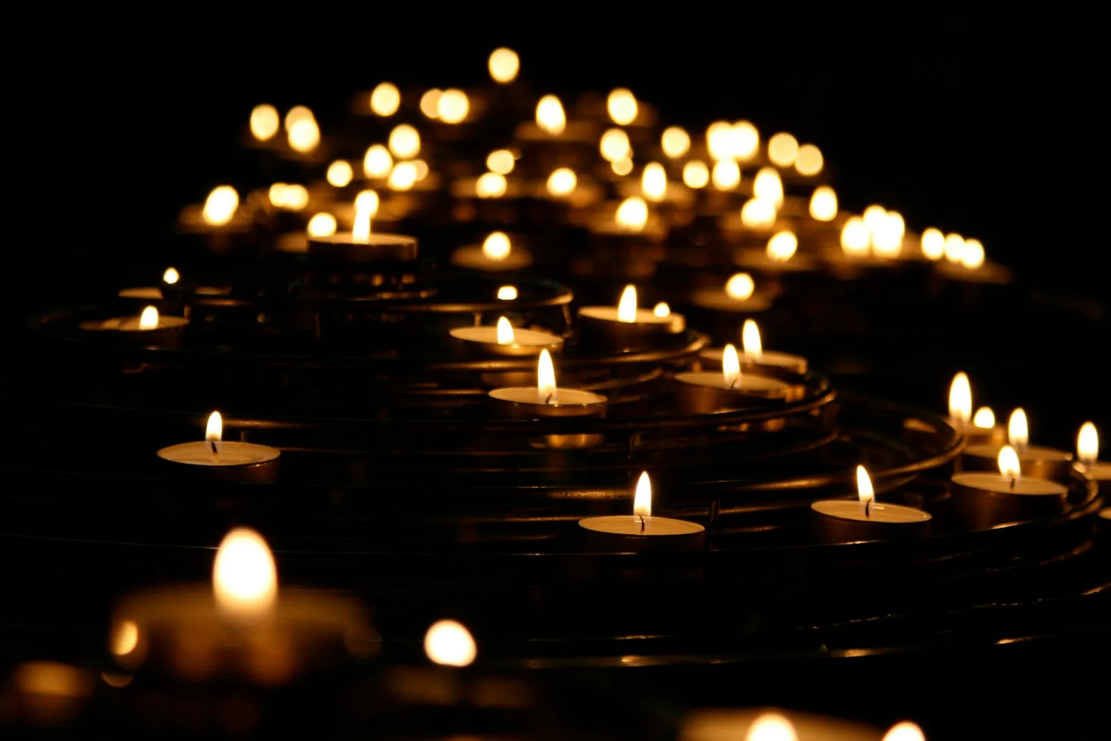 Queens wrongful death lawyer: rows of lit memorial candles glowing in the dark