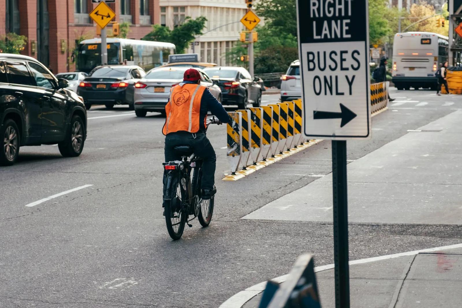 Cyclist riding next to parked and moving cars