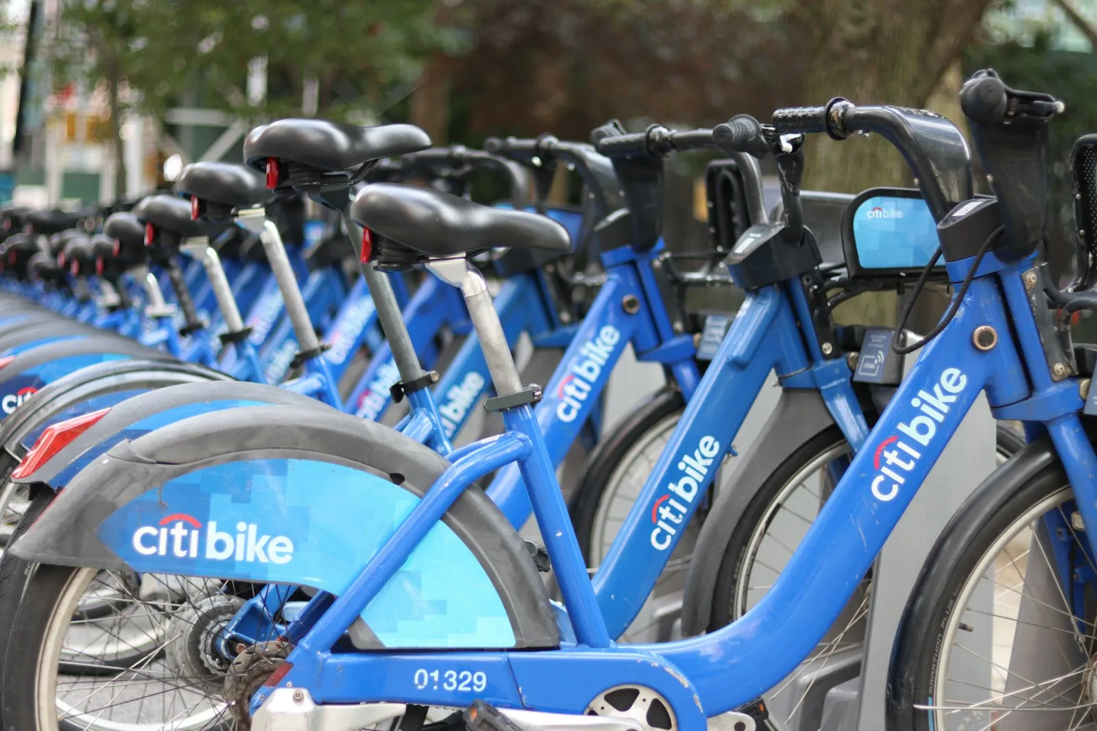 Row of blue bike share bicycles docked at a station