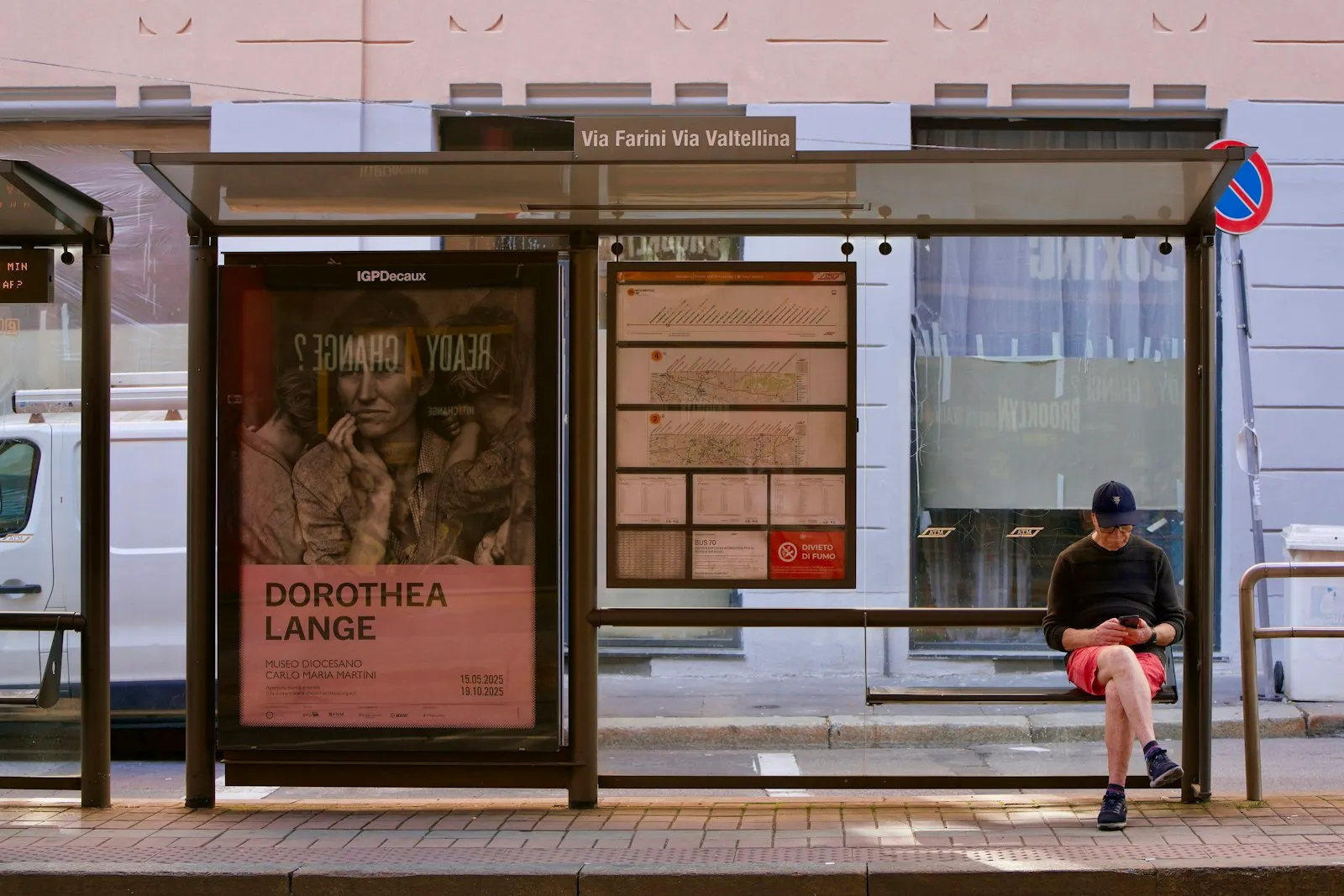 Woman waiting at a bus stop checking her phone