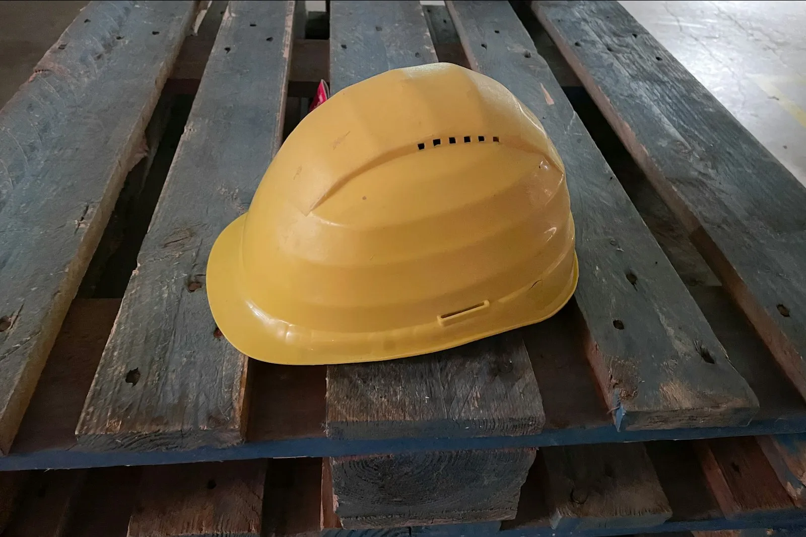 Casco amarillo descansando en una superficie de madera