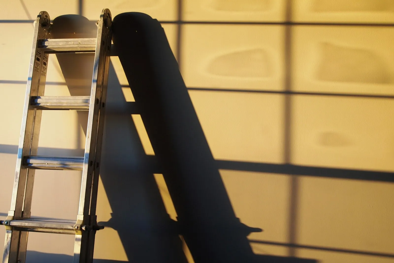Escalera metálica apoyada contra una pared