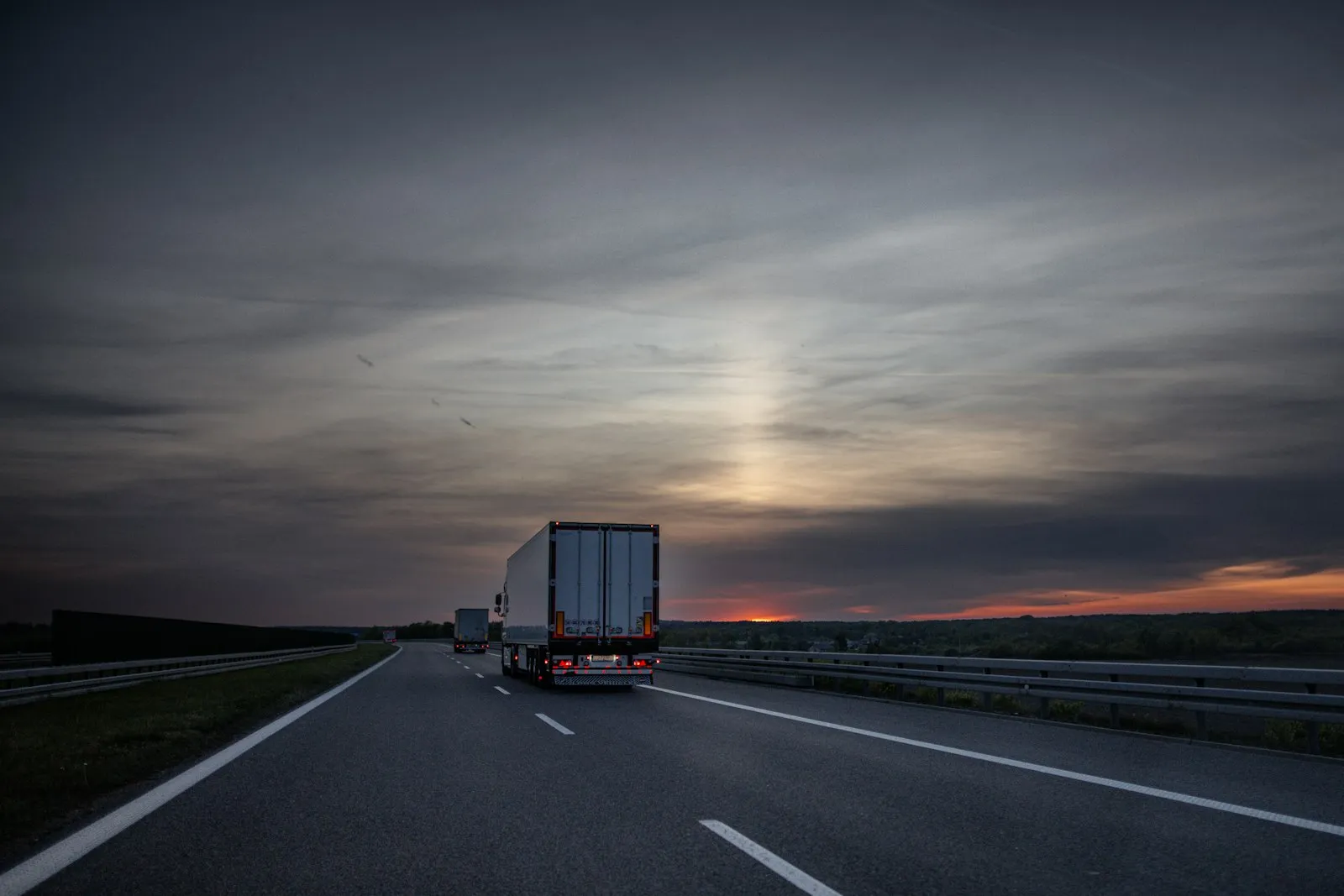 Camions sur une autoroute au coucher du soleil