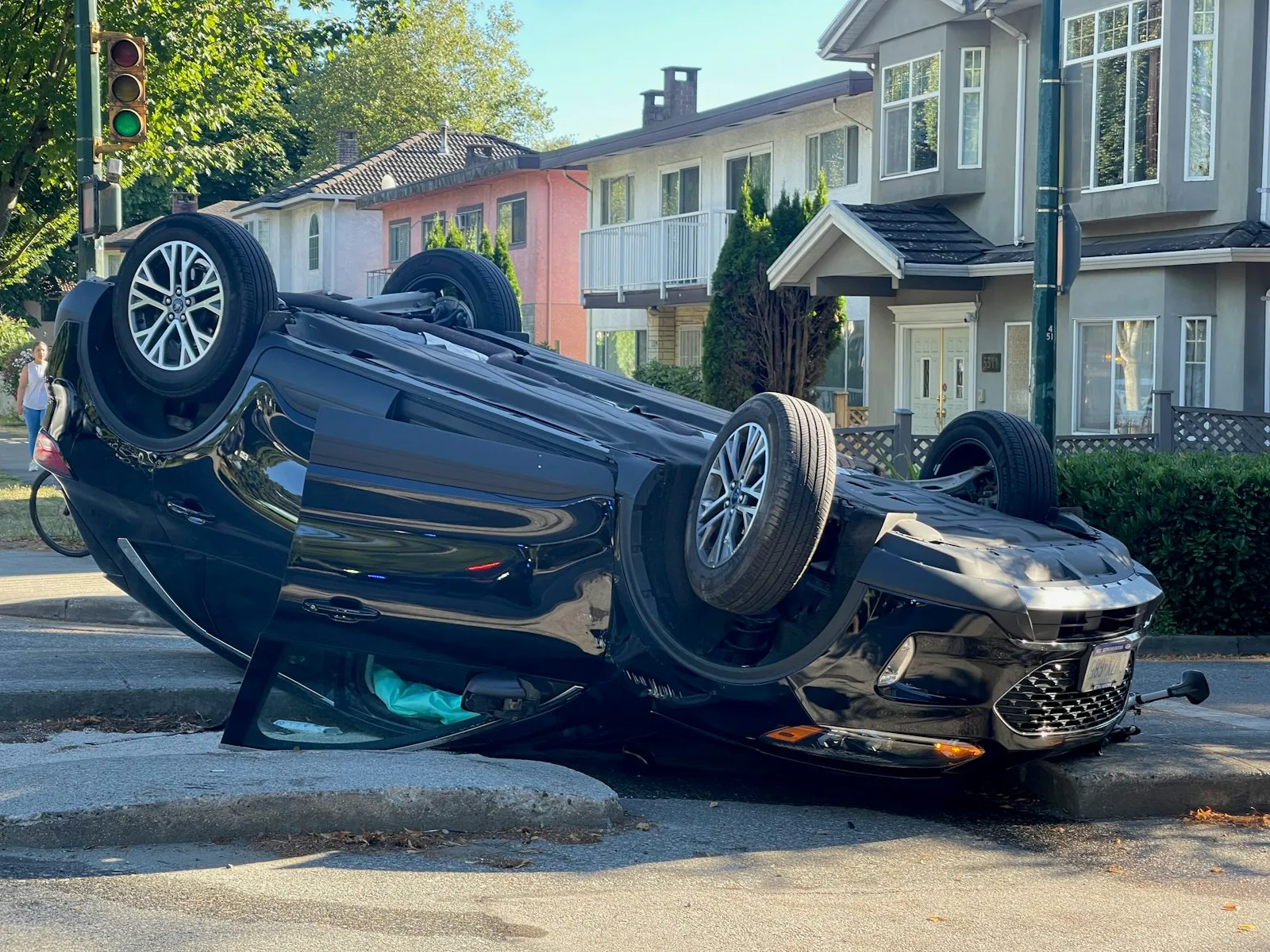 Car flipped upside down on its roof on a residential street, the kind of crash a rollover accident lawyer investigates