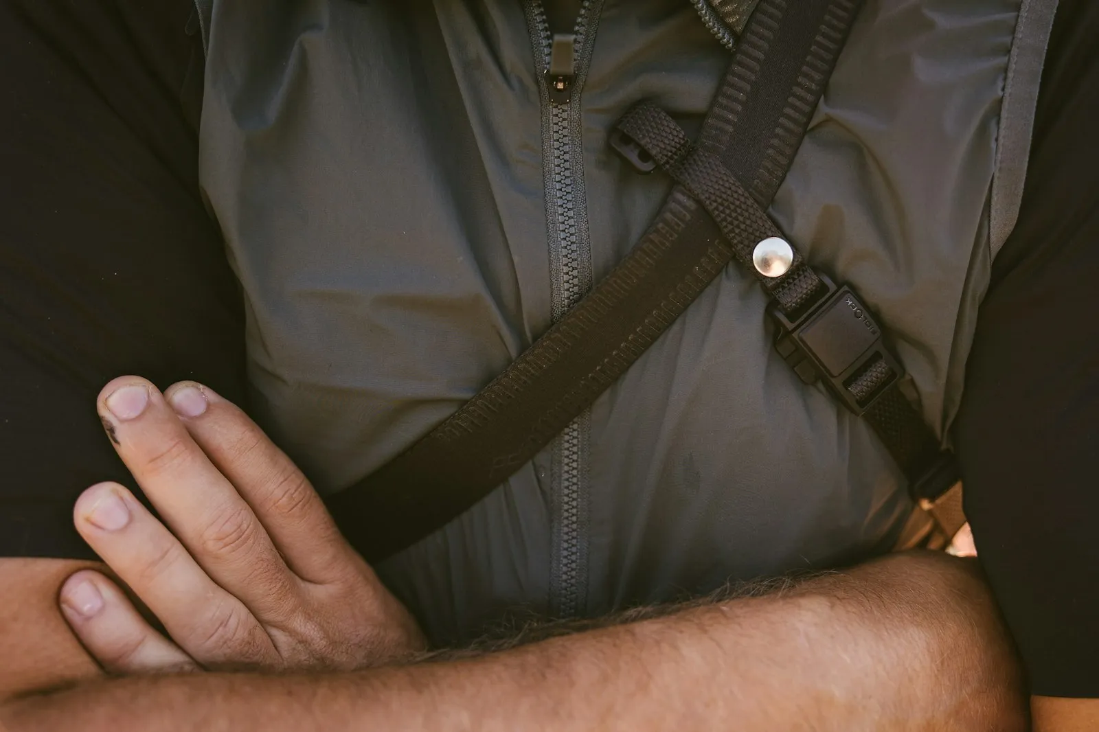 Man with his arm supported in a black sling across his chest while consulting a shoulder injury attorney