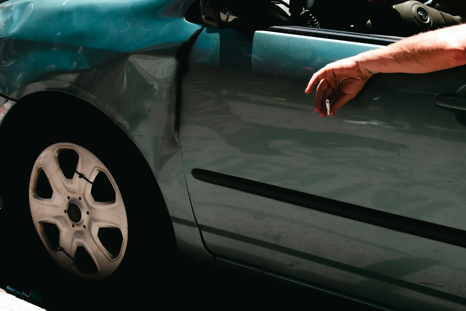 Dented side panel and door of a car after a collision, shown in a sideswipe accident attorney article