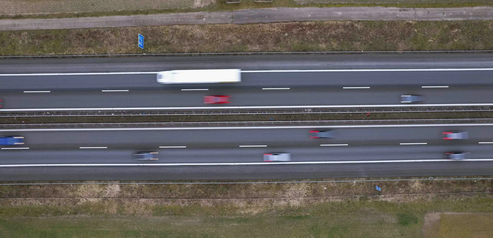 Sideswipe accident lawyer article image: aerial view of a multi-lane highway with cars and a truck in motion