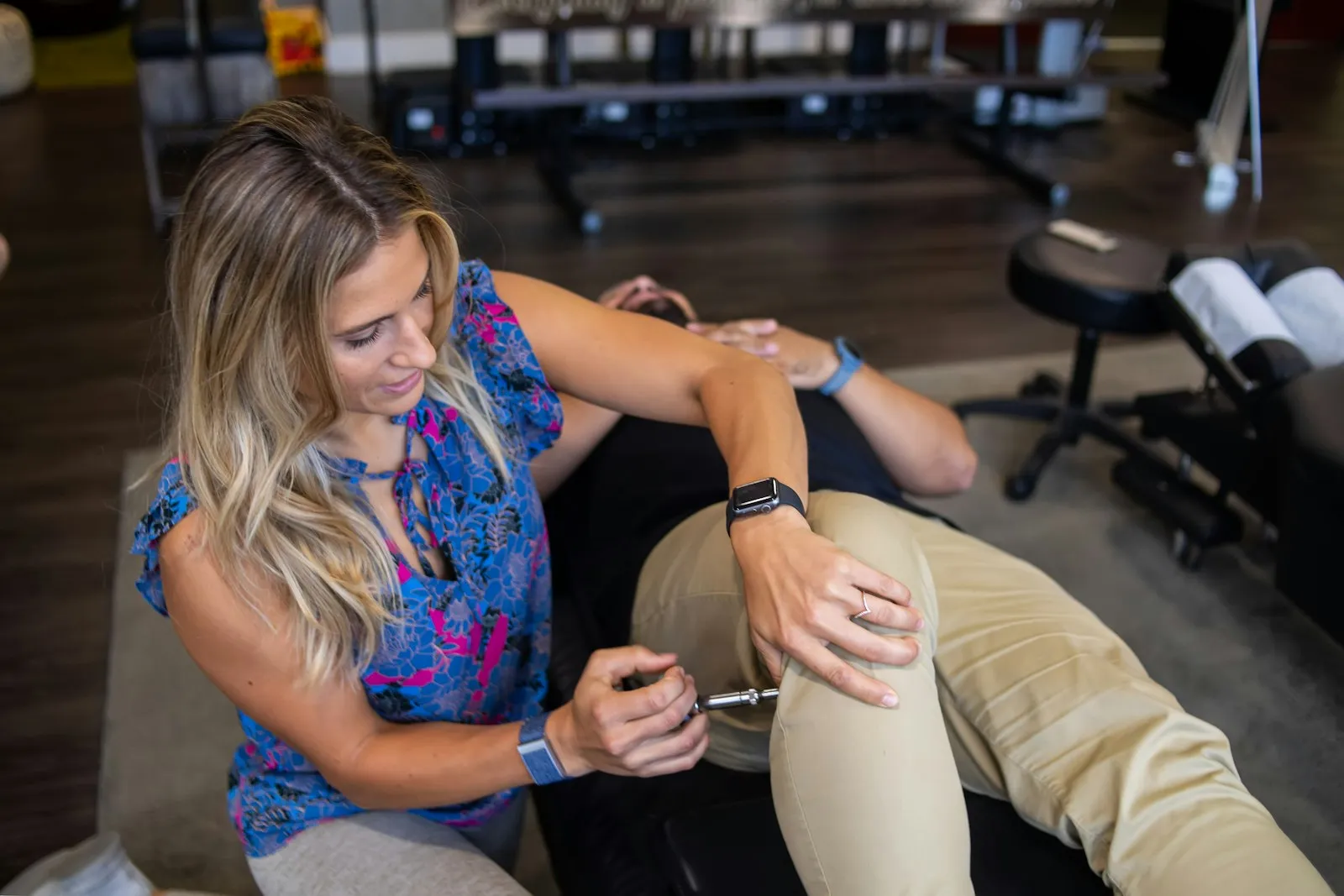 What is an IME: medical examiner testing the knee of a woman seated on an exam table